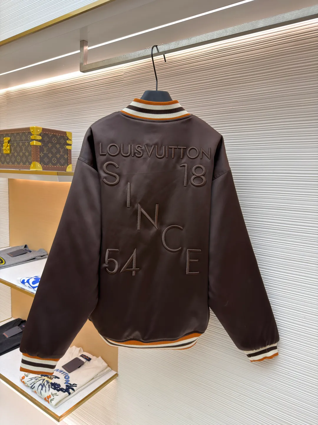LOUIS VUITTON decorative flight jacket ●Original version: 30,000 purchased and developed ●Item number: 1682285-B90 ●Fabric: cotton fabric ●Technology: patch production ●Color: brown ●Version: fitted version ●Weight: about 1085 grams ●Size: 46-48-50-52 ●Description: The main body of this Louis Vuitton satin baseball jacket is made of high-density matte satin fabric, which has been treated with anti-wrinkle shaping technology. The fabric has a strong drape and is not easy to wrinkle. The dark brown background color is prepared by precision dyeing and finishing technology, giving it a rich color and high-end texture. The "L.V.M SINCE 1854" logo on the left chest is made with hot-drilling technology. High-quality rhinestones are used for precise hot-pasting in different areas. The diamond surface is shiny and strong and will not fall off easily. The ribbed splicing of the collar, cuffs and hem is a three-color contrasting design. It is woven with high-elastic knitted yarn, which will not easily loosen and deform after long-term wear. The placket is equipped with custom-made metal snaps. The hardware is thick and anti-oxidation. The overall style is loose and off-shoulder. The splicing is covered with blind stitching technology, and the wiring is smooth and traceless. Every craft detail follows the brand's luxury product production standards, taking into account both design and wearing comfort. The overall wiring is straight and delicate, the fabric is comfortable and soft, and the color is consistent without color difference. It can be matched with the same style to create a fashionable look and control various occasions. Customized accessories, complete with three standards, same style for men and women!